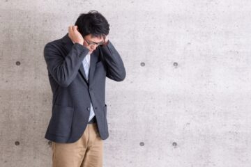 耳をおさえる男性